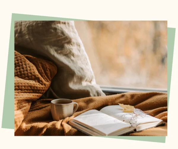 Ein geöffnetes Buch und eine Tasse auf einer warmen Decke – Symbol für Ruhe, Geborgenheit und Vorbereitung in der Trauer.